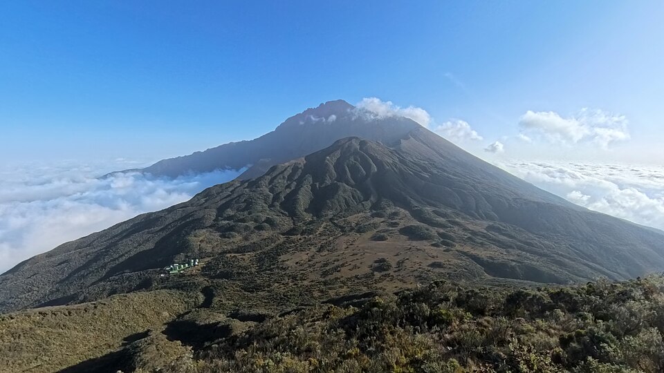 Mount Meru w Tanzanii – złożona budowla wulkaniczna położona w obrębie wschodnioafrykańskiego systemu ryftowego. Jej współczesna morfologia jest wynikiem kolejnych faz aktywności wulkanicznej oraz wielkich osuwisk i zapadania się części starszej budowli. Fot. AmyAbroad, CC BY-SA 4.0, via Wikimedia Commons