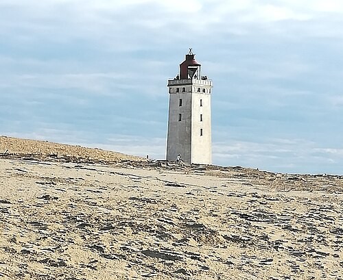 Latarnia morska Rubjerg Knude na zachodnim wybrzeżu Jutlandii w sierpniu 2019 r., krótko przed rozpoczęciem operacji jej przenoszenia. Postępująca erozja klifu sprawiła, że budowla znalazła się niebezpiecznie blisko Morza Północnego. Fot. Chrischi1983, Wikimedia Commons, CC BY-SA 4.0.