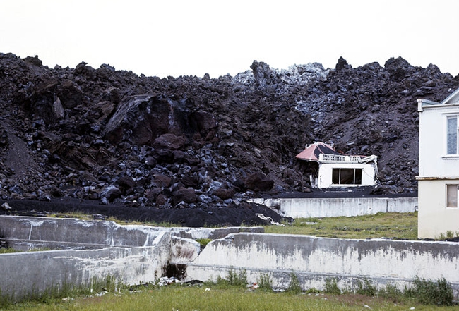 Budynek pogrzebany przez lawę po erupcji wulkanu Eldfell na wyspie Heimaey (Islandia, 1974). Źródło: USGS i Wikimedia Commons